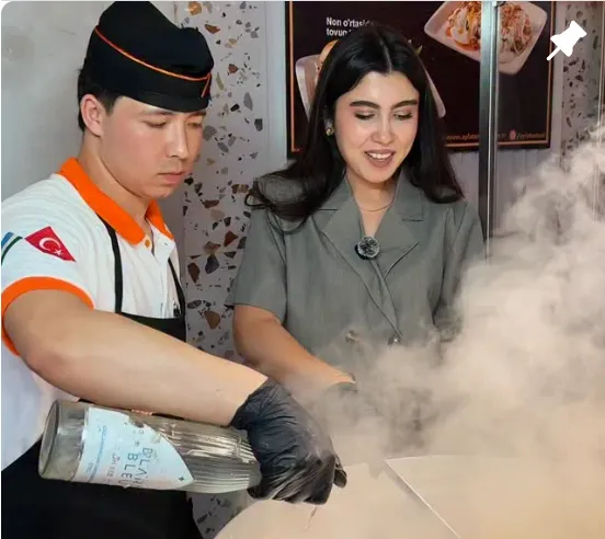 Ayla tantuni oshpazi qizigan toshda tantuni tayyorlamoqda, mehmon yonida kuzatmoqda